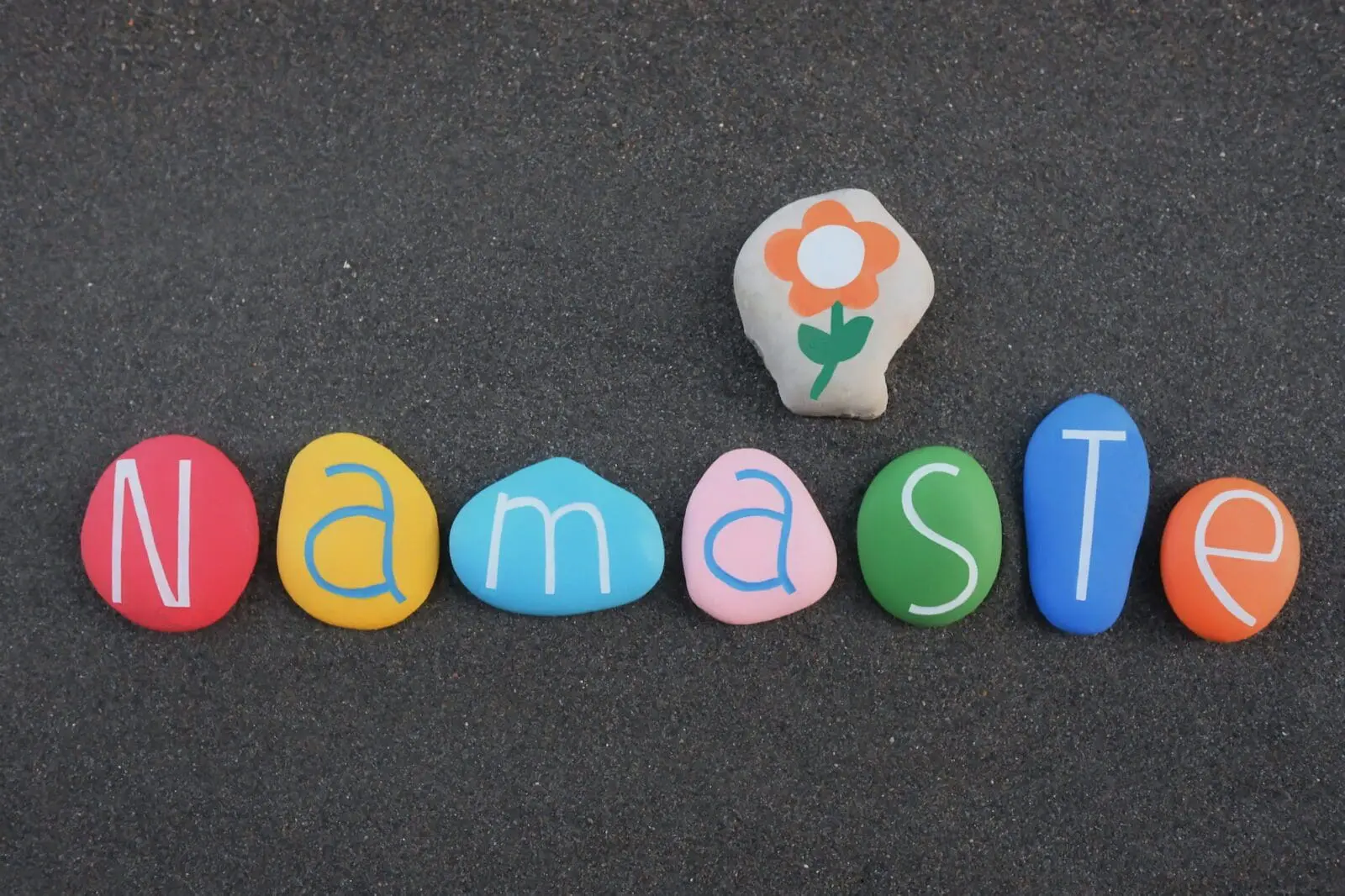 Namaste, creative text composed with colored stone letters