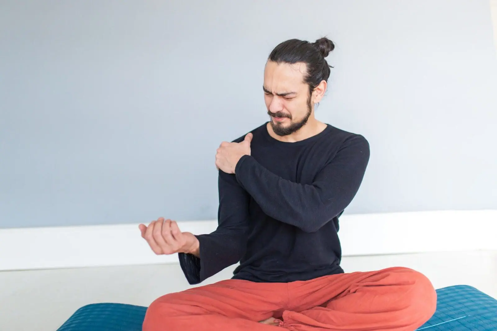 Young athletic man is suffering pain from his wrist during workout or yoga