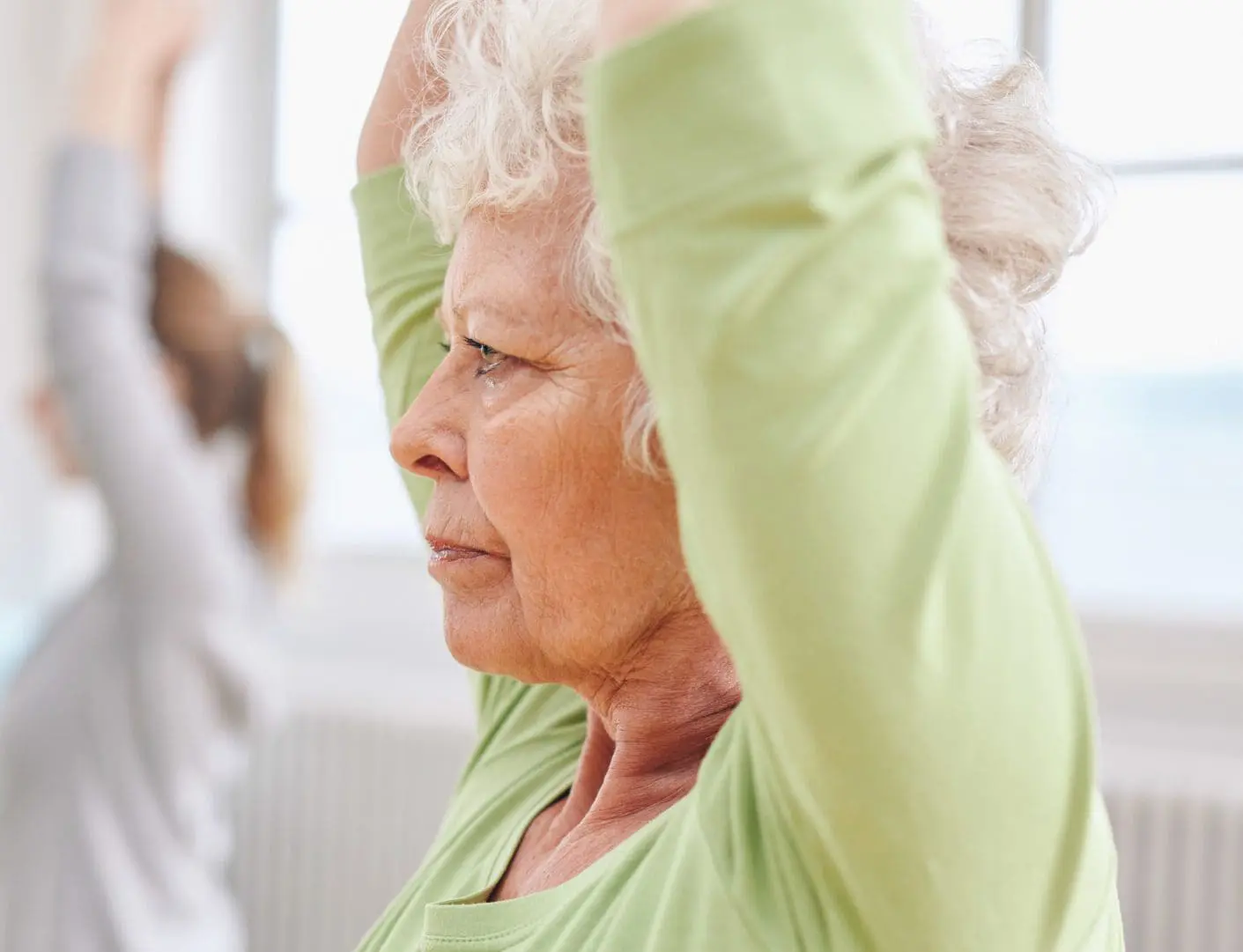 Senior woman practicing yoga at gym