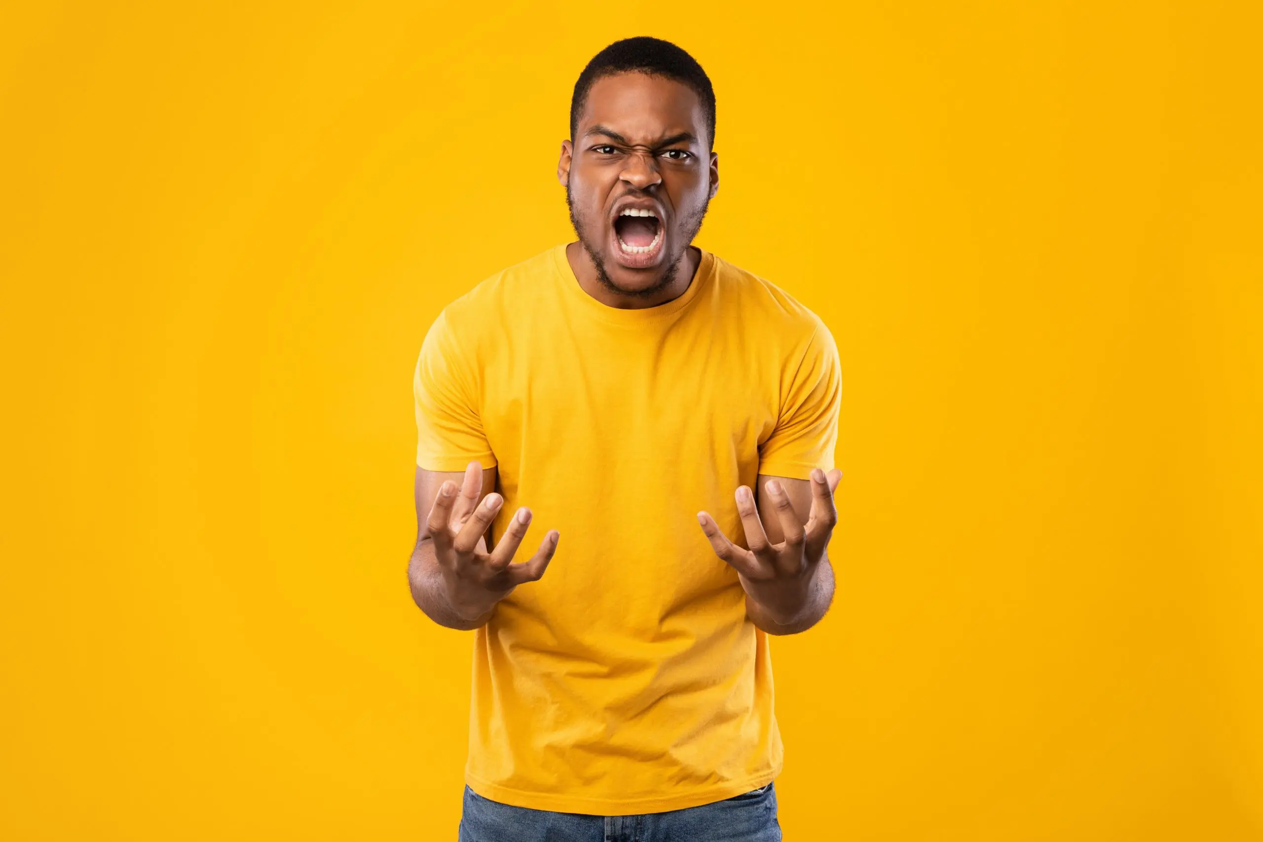 Angry African American Man Shouting Expressing Anger Over Yellow Background