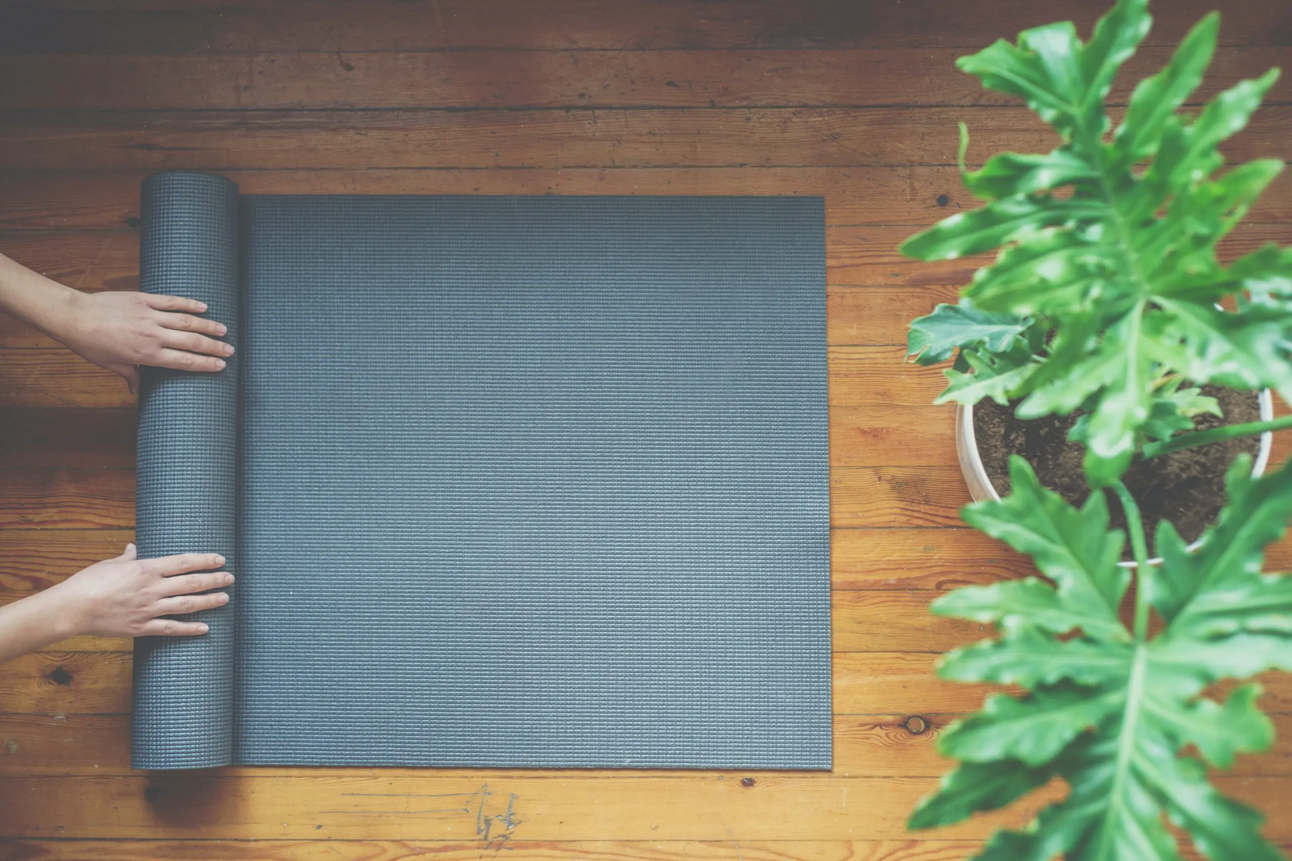 Woman rolling her mat after a yoga class, top view