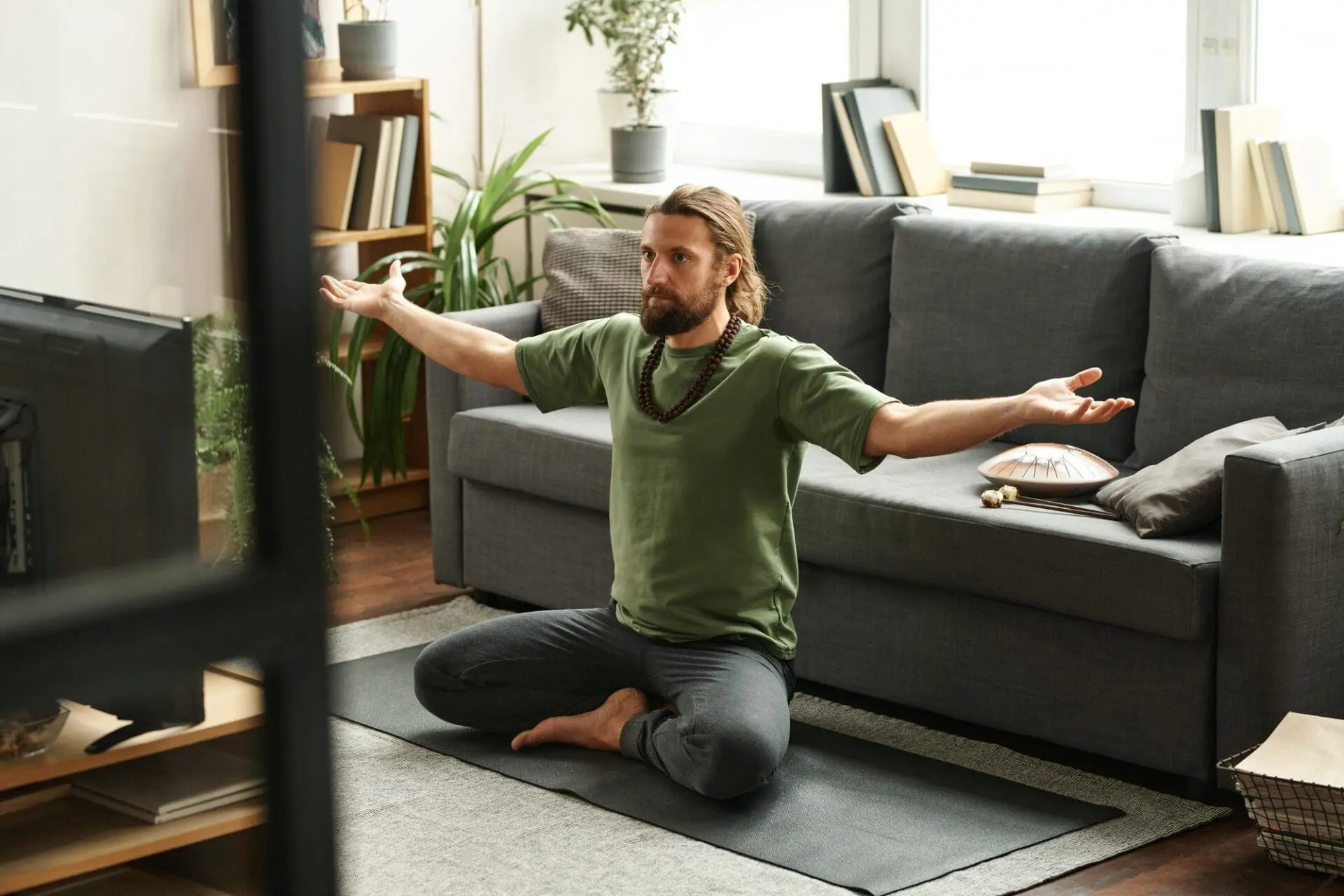 Man watching TV to do yoga at home