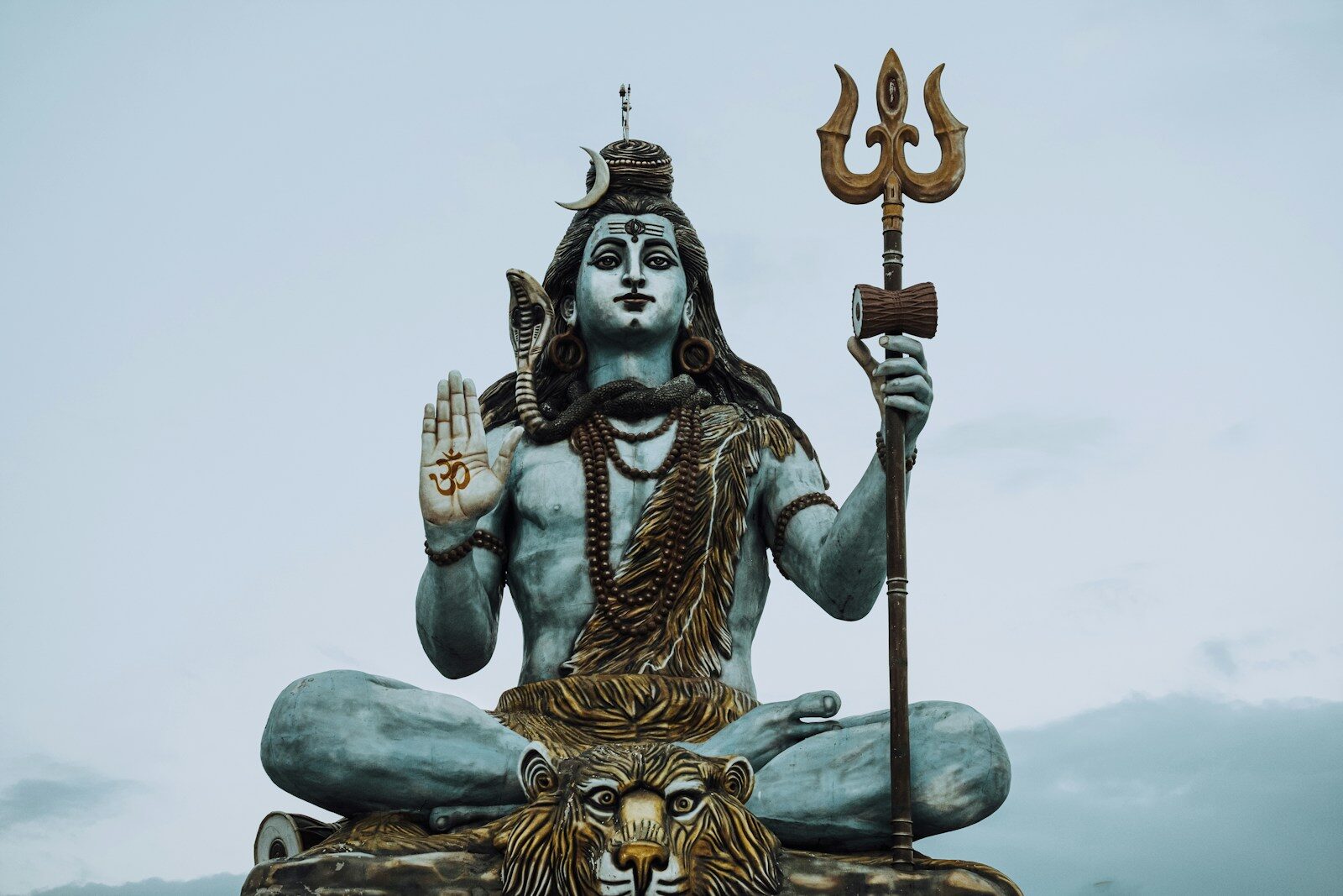 A statue of a hindu god sitting on a rock