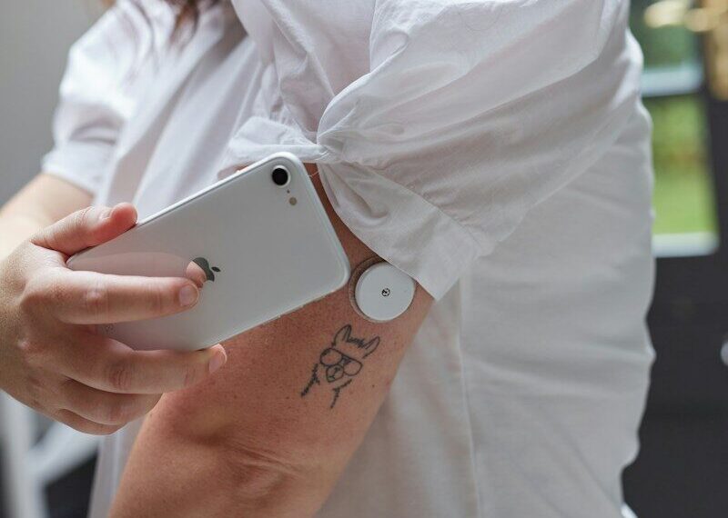 a person scanning blood glucose with a flash glucose monitor